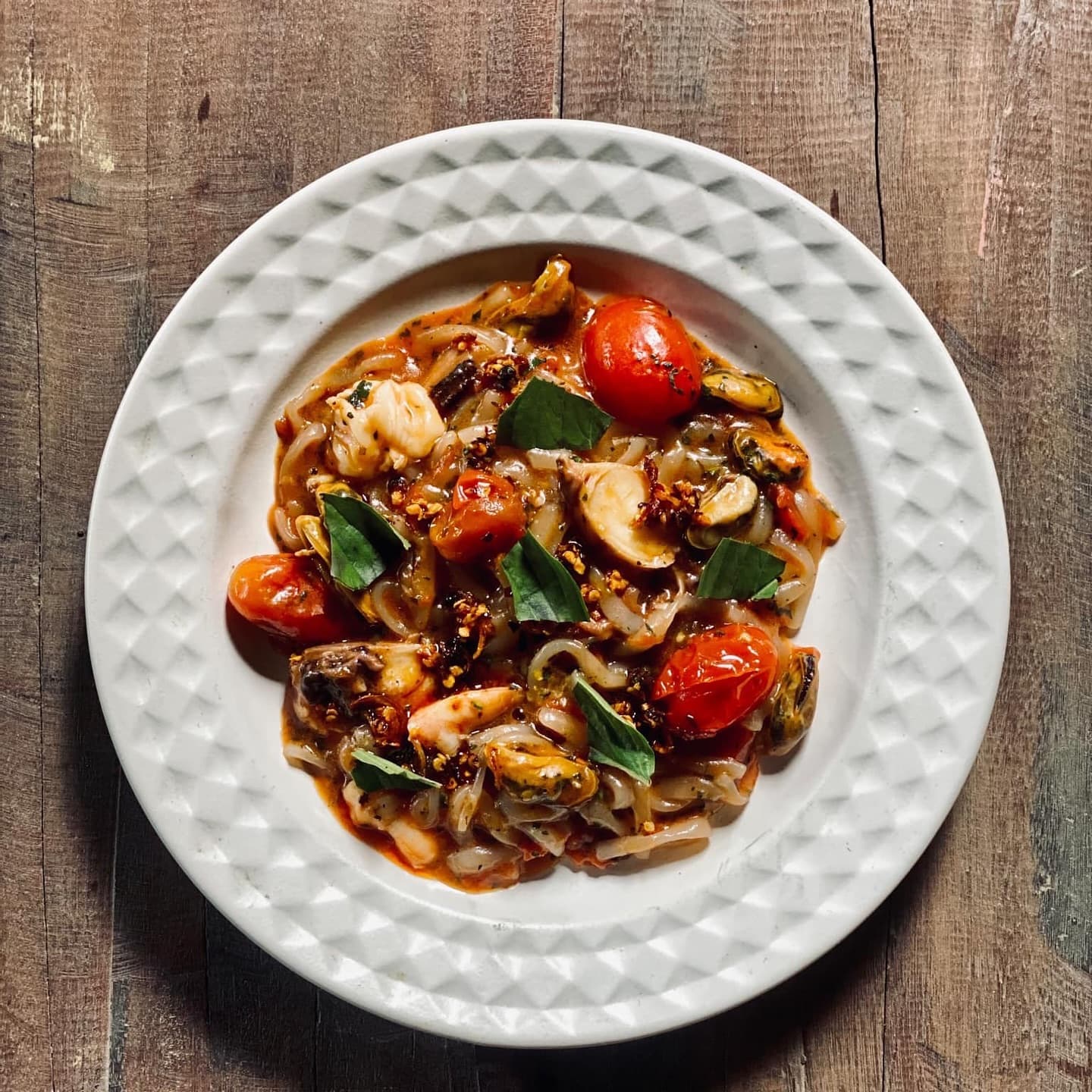 Handmade pasta with seafood, mussels and blistered cherry tomatoes in a rich tomato sauce