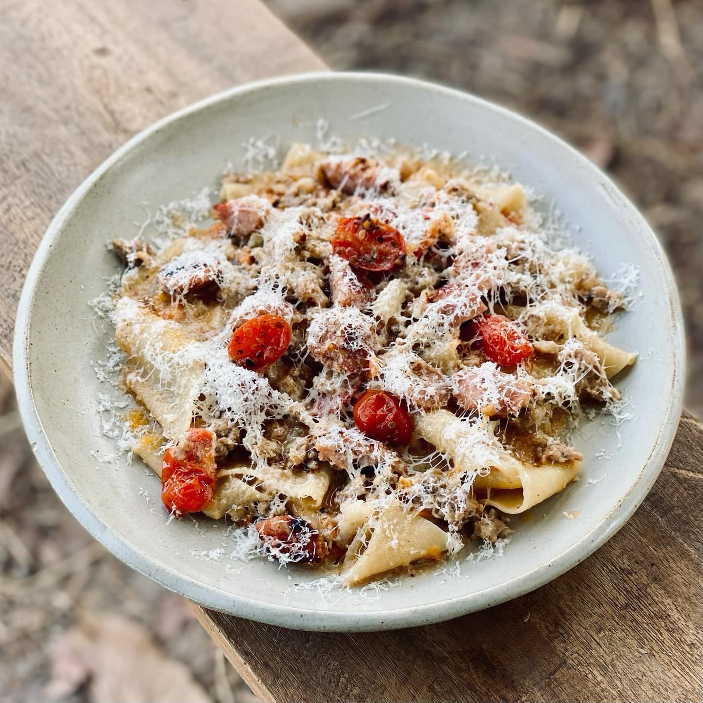 Hand-cut pappardelle with slow-cooked ragù, charred tomatoes and shaved cheese