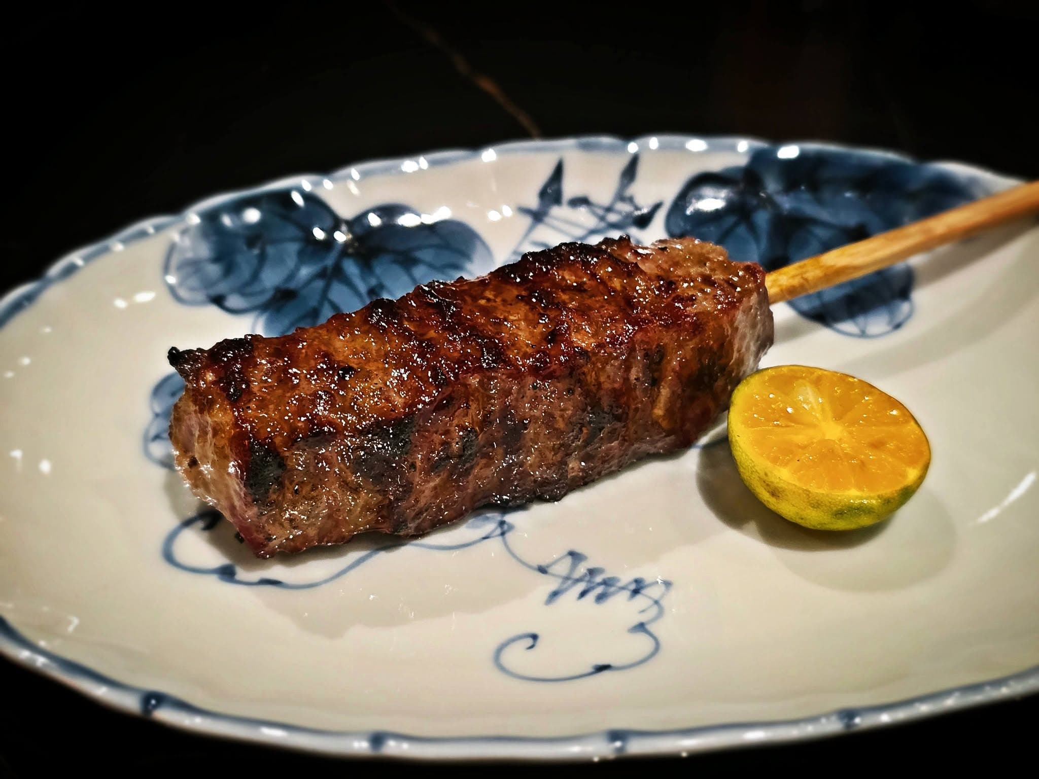 Char-grilled beef skewer with citrus on hand-painted blue and white porcelain